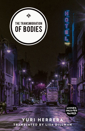 Transmigration of Bodies cover art. A purple-tinged photograph of a city street