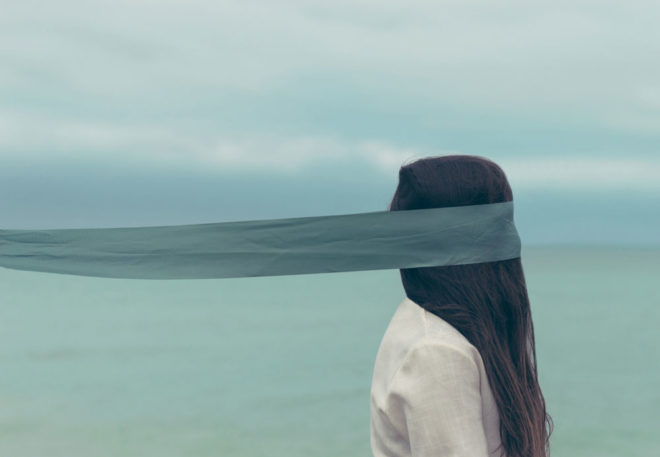 Woman blindfolded against ocean