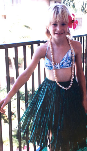 Claire Rudy Foster as a young girl wearing a flower in her hair and a grass skirt