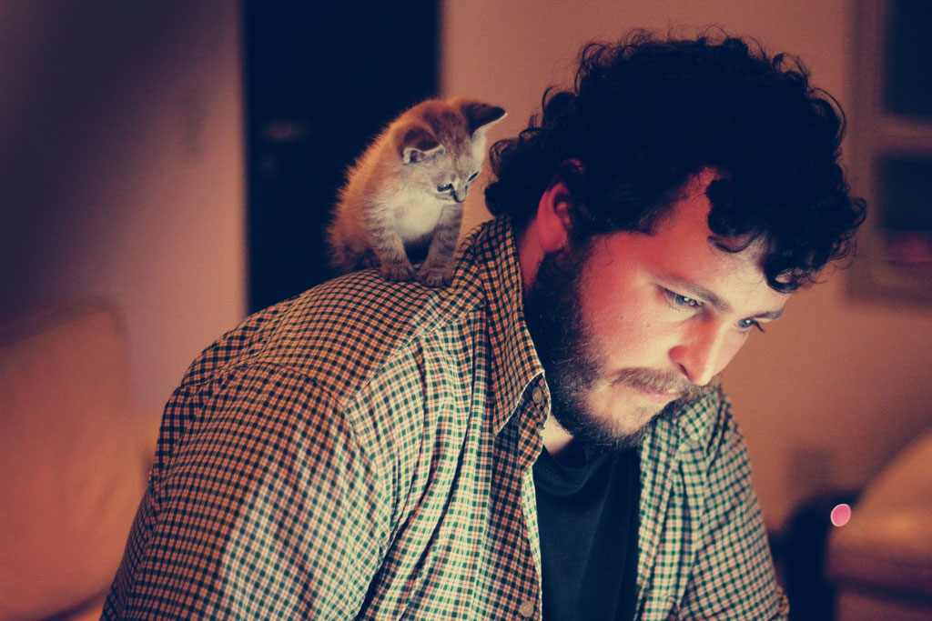 best-reader-worst-enemy, man looking down with kitten on his shoulder