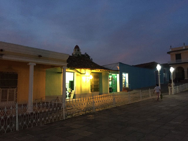 lit-up building in row of colorful buildings against dark sky