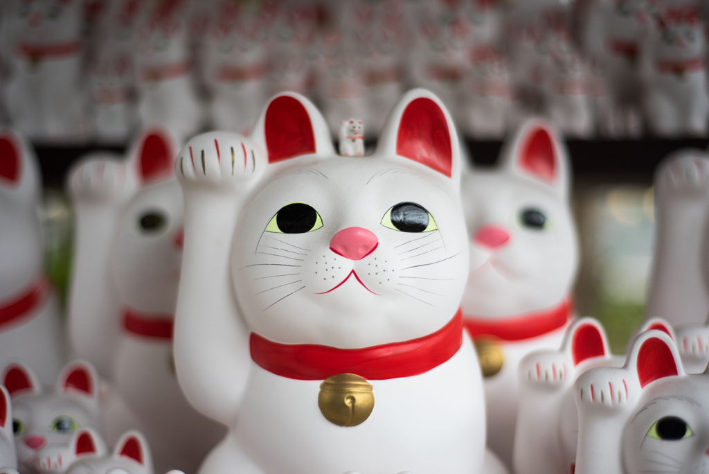 Cat figurines with one hand held up