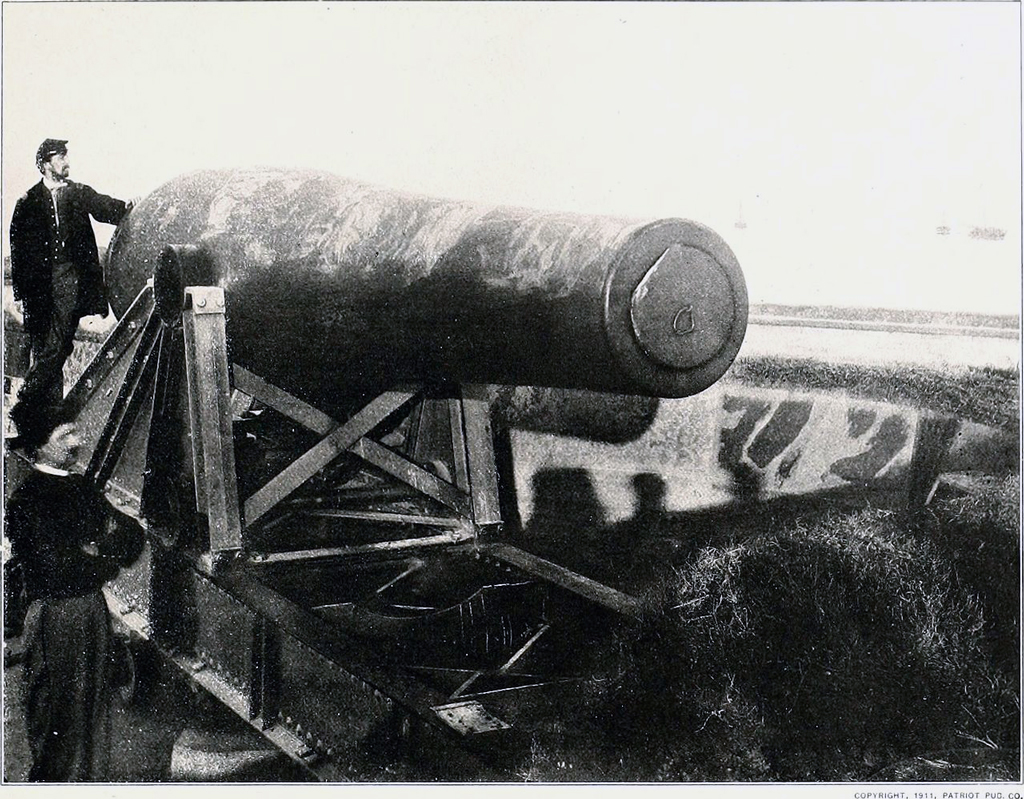 Vintage photo of man standing next to military cannon