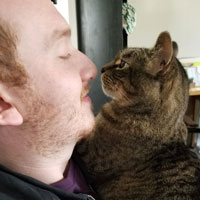 Headshot of Justin Goodman and his cat