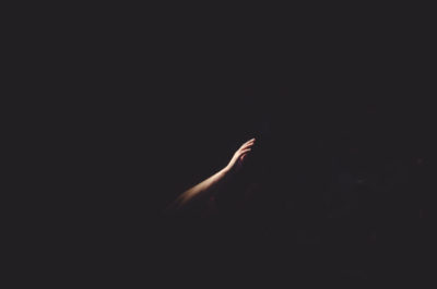 Man's arm upraised against a dark background