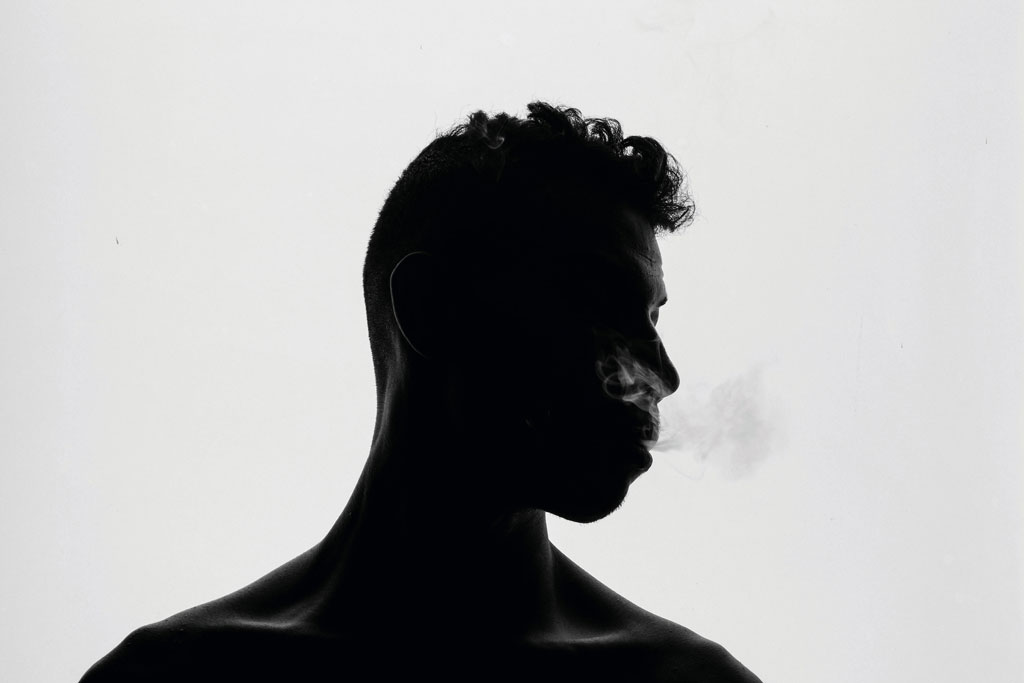 silhouette of a man smoking
