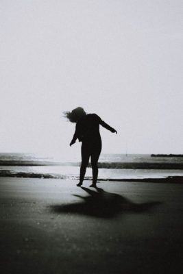 black and white image of a girl on the beach