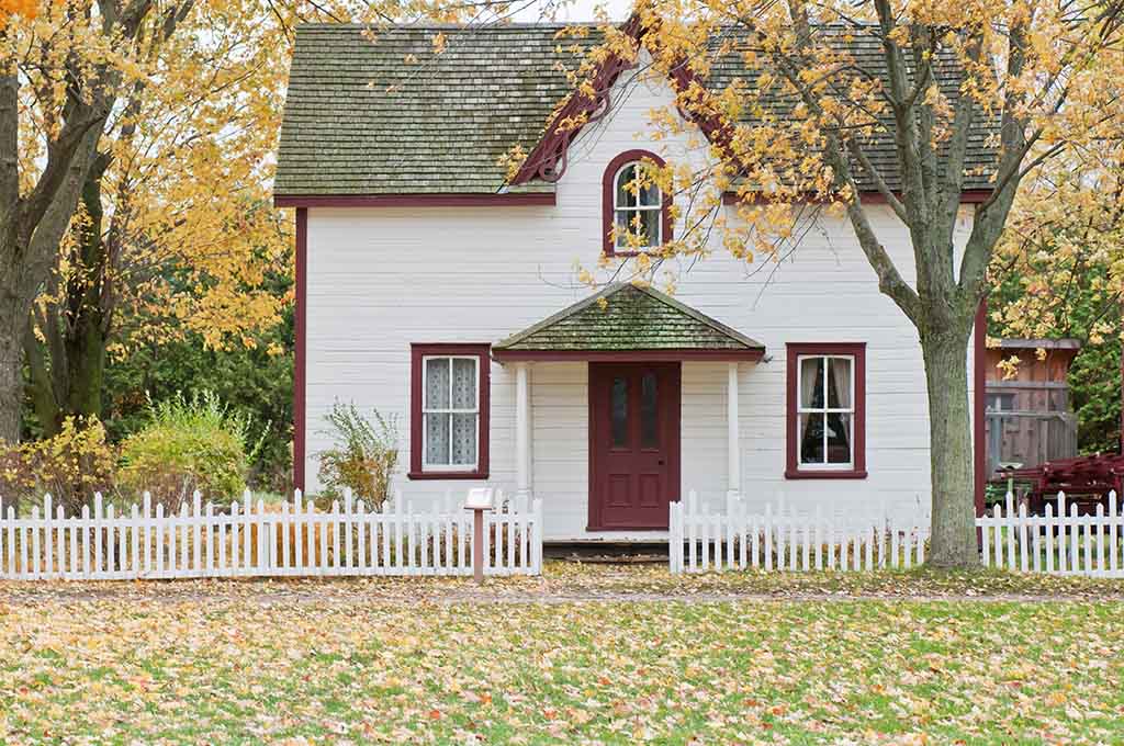 Picture of a victorian style house behind a white picket fence
