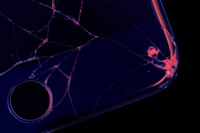 abstract image of cracked phone screen in black, purple, and magenta