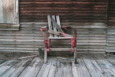 an old chair on a rotting porch